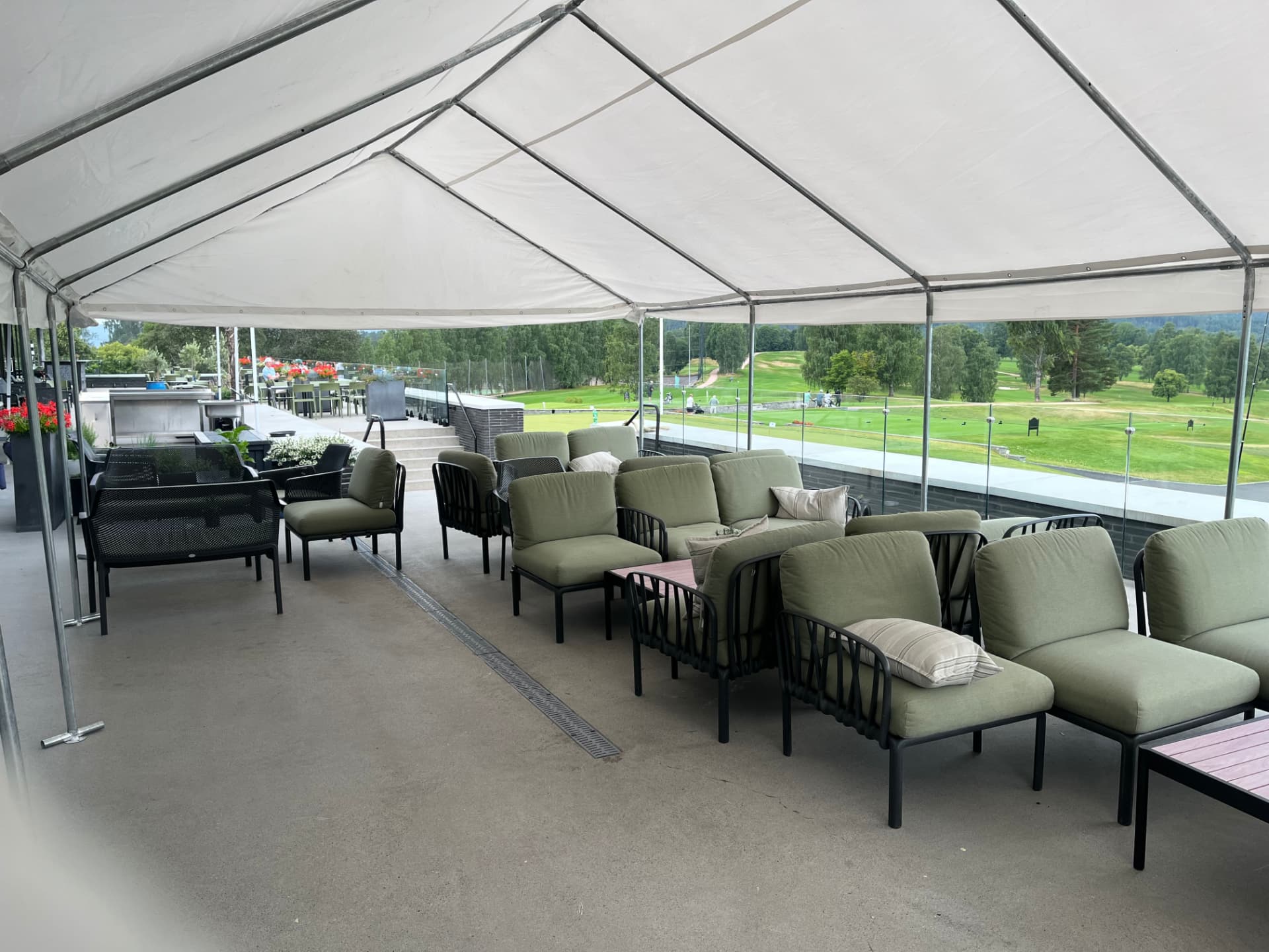 Stort partytelt med loungemøbler ved golfbane